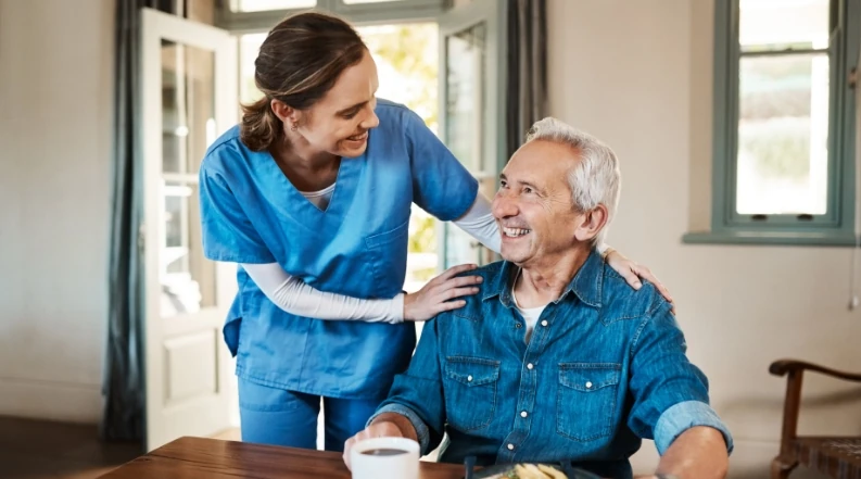 Pflegerin mit Patient beim Frühstück